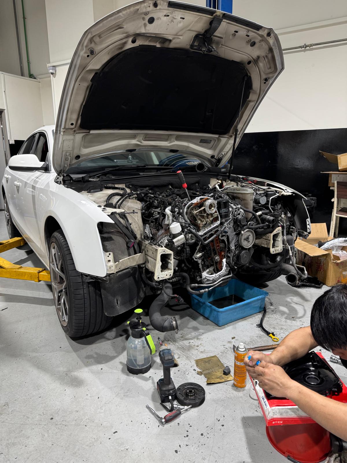 Technician working on an Audi A5 engine bay at TEC AUTO SERVICES independent European car workshop in Singapore