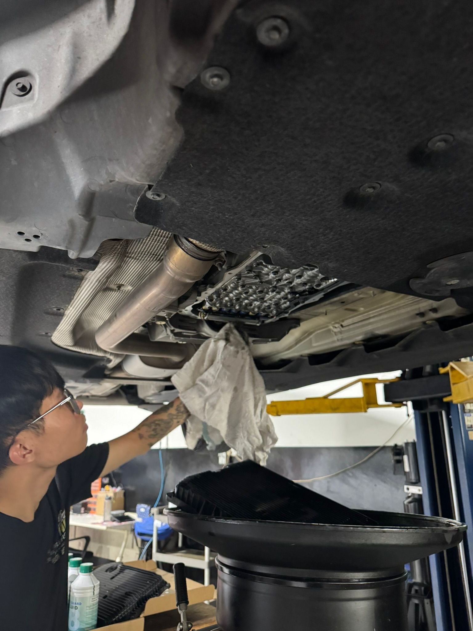 TEC AUTO technician inspecting the underside of a BMW on the ramp at our Woodlands workshop in Singapore